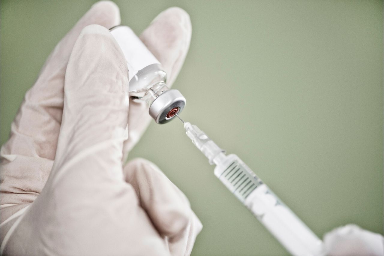 imagem de um médico segurando uma ampola de vacina